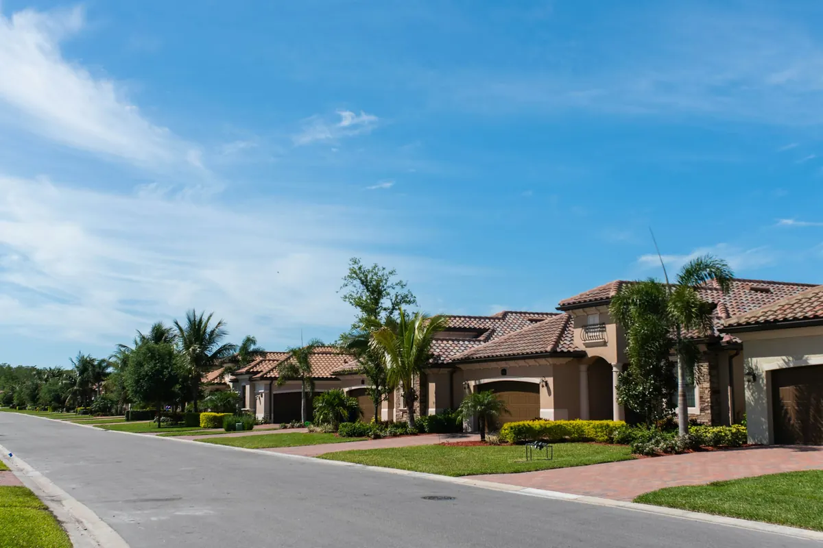 Home Insurance in Port St. Lucie, FL: illustrative street of single-family homes with tile roofs and palms